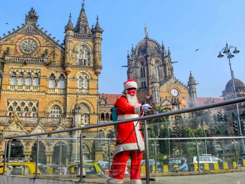Mumbai: A worker dressed as Santa Claus sanitizes the area around Chhatrapati Shivaji Maharaj Terminus, in Mumbai, Thursday, Dec. 17, 2020. (PTI Photo)