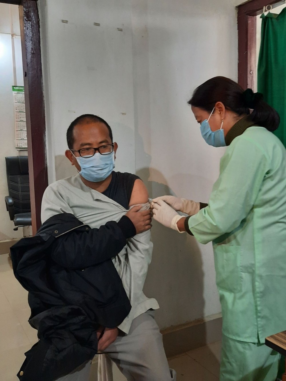 Nurse at Mokokchung’s Imkongliba Memorial District Hospital giving the first COVID-19 vaccine to Dr HT Sangtam, Senior Specialist, IMDH, the first person to get vaccinated in the district on January 16. (Morung Photo)