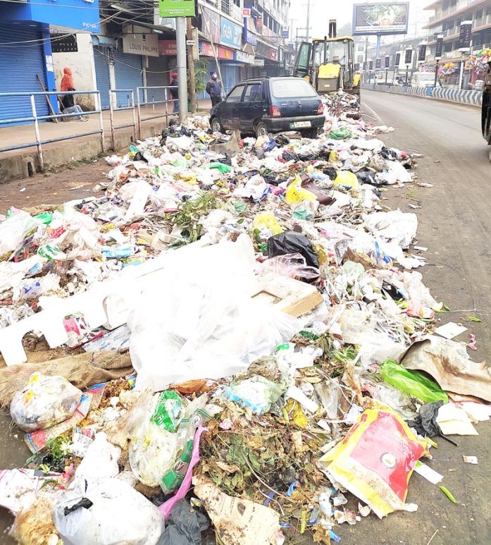 Dimapur Municipal Council (DMC) sanitation workers using an excavator to clear up garbage accumulated on the streets of Dimapur town on January 17 morning. (Morung Photo)