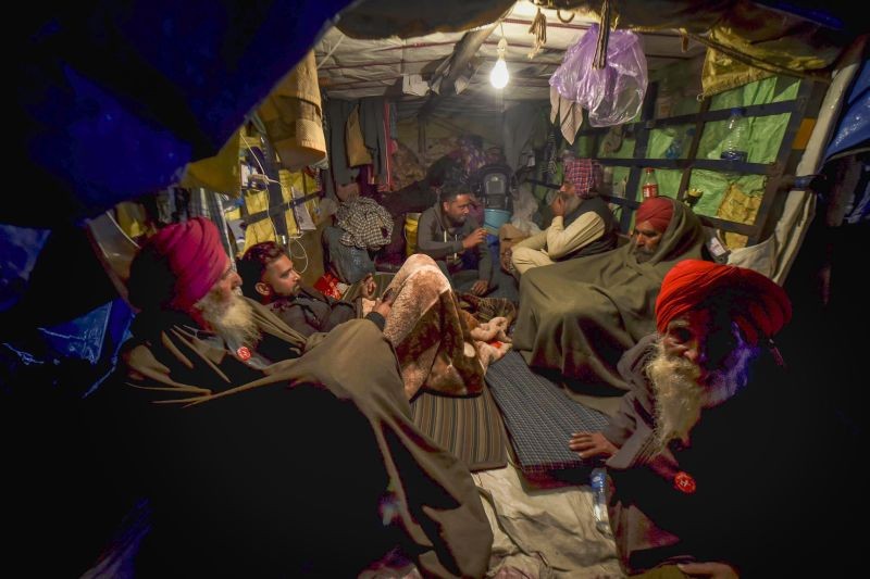 New Delhi: Farmers rest inside a tractor trolley during their agitation against new farm laws, at Singhu border in New Delhi, Tuesday, Jan. 12, 2021. (PTI Photo/Shahbaz Khan)