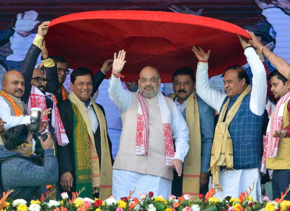 Nalbari: Union Home Minister Amit Shah being presented a traditional Assamese 'japi' during BJP's Bijoy Sankalpo Samabhekh public rally in Nalbari, Assam, Sunday, Jan. 24, 2021. (PTI Photo)