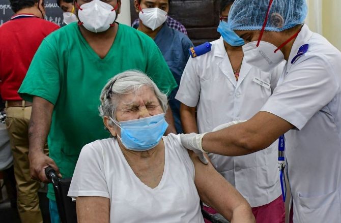 A medic administers the first dose of Covishield vaccine to 87-year-old Dr Asha Singhal, at South Mumbai Nair Hospital in Mumbai, on Saturday. Photograph: PTI Photo