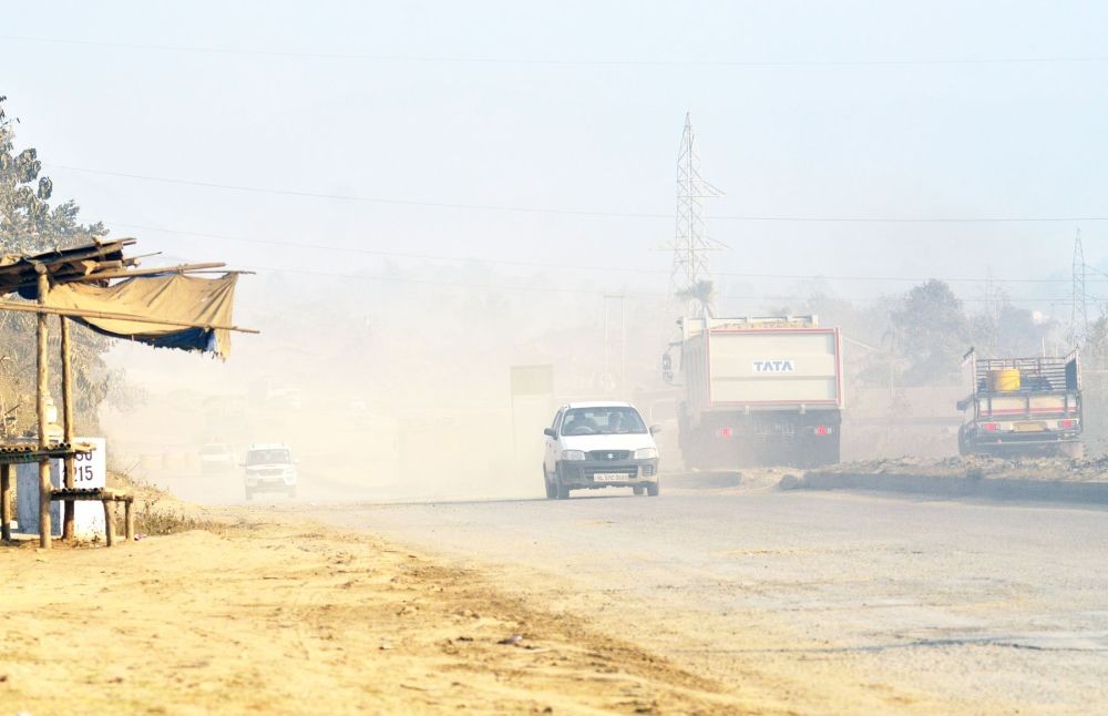 A constant surge of dust kicked up by vehicles envelopes the air on the highway at Kukidolong, near Jharnapani. (Photo courtesy: Caisii Mao)