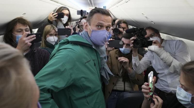 Kremlin critic Alexei Navalny is surrounded by journalists inside the plane prior to his flight to Moscow in the Airport Berlin Brandenburg (BER) in Schoenefeld, near Berlin, Germany, Sunday, Jan. 17, 2021. (AP /Mstyslav Chernov)