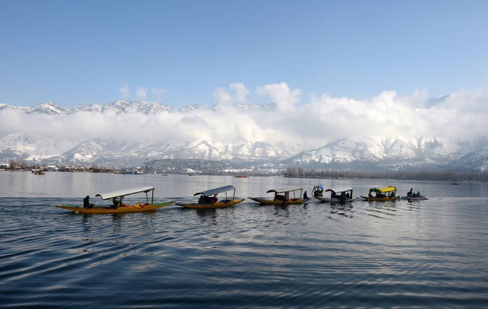 Srinagar: Boatmen row their Shikaras during a sunny day after a fresh snowfall, in Srinagar, Sunday, Jan. 24, 2021. (PTI Photo/S. Irfan)