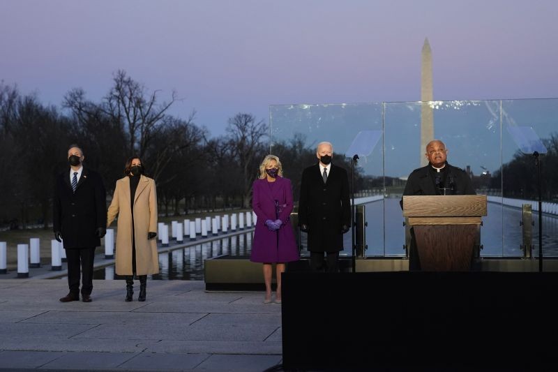 President-elect Joe Biden and his wife Jill, along with Vice President-elect Kamala Harris and her husband Doug Emhoff, listen as Cardinal Wilton Gregory, Archbishop of Washington, delivers the invocation during a COVID-19 memorial, with lights placed around the Lincoln Memorial Reflecting Pool on January 19, 2021, in Washington. (AP/PTI Photo)
