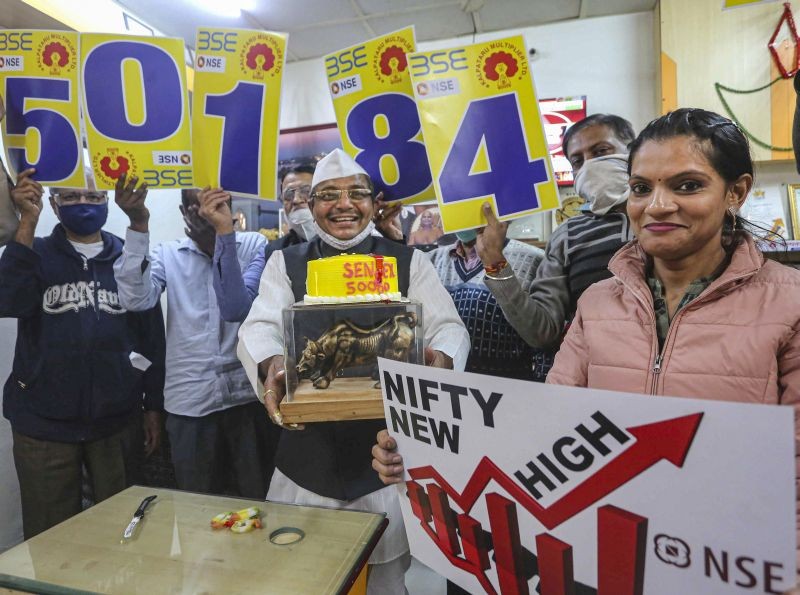 Share brokers and investors celebrate after the sensex crossed 50,000 mark for the first time, at a share terminal in Bhopal on January 21, 2021. (PTI Photo)