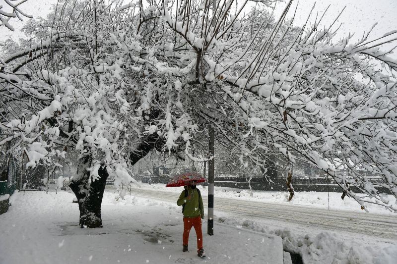 Srinagar: Vehicles move slowly on a snow-covered road during heavy snowfall, in Srinagar, Tuesday, Jan. 5, 2021. (PTI Photo/S. Irfan)