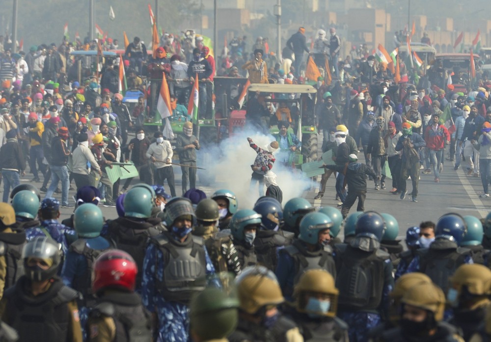 Police uses tear gas to disperse farmers attempting to break barricades at Ghazipur border during their Kisan Gantantra Parade, on the occasion of 72nd Republic Day, in New Delhi on January 26. (PTI Photo/Ravi Choudhary)