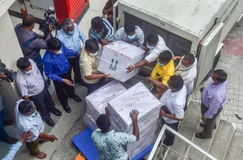 Workers unload packets containing Covishield vaccine after the first batch of  vaccines from the Serum Institute of India arrived at a storage facility in Chennai on January 12, 2021. (PTI Photo)