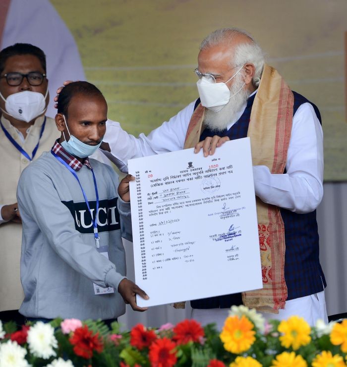 Sivasagar: Prime Minister Narendra Modi distributes 'Land Patta' to a man during a public meeting, at Jerenga Pathar in Sivasagar District of Assam, Saturday, Jan. 23, 2021. (PTI Photo)