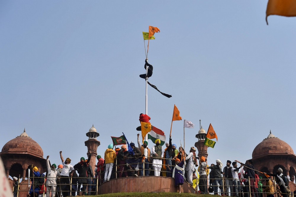 Farmers hoist flags at the Red Fort during the Kisan Gantantra Parade amid the 72nd Republic Day celebrations, in New Delhi on January 26. (PTI Photo)