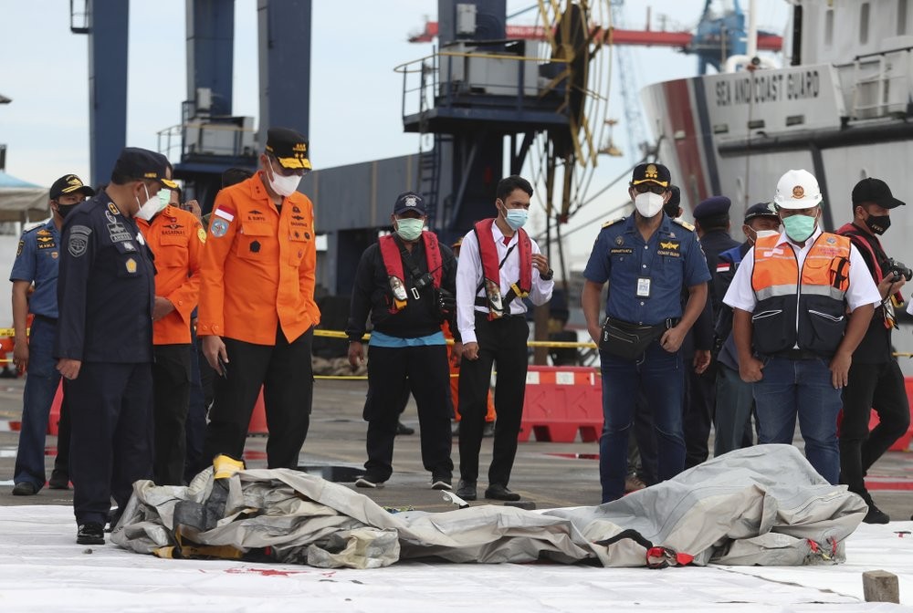 Rescuers inspect debris found in the waters around the location where a Sriwijaya Air passenger jet has lost contact with air traffic controllers shortly after the takeoff, at the search and rescue command center at Tanjung Priok Port in Jakarta, Indonesia, Sunday, Jan. 10, 2021. The Boeing 737-500 took off from Jakarta for Pontianak, the capital of West Kalimantan province on Indonesia's Borneo island, and lost contact with the control tower a few moments later. (AP Photo/Achmad Ibrahim)