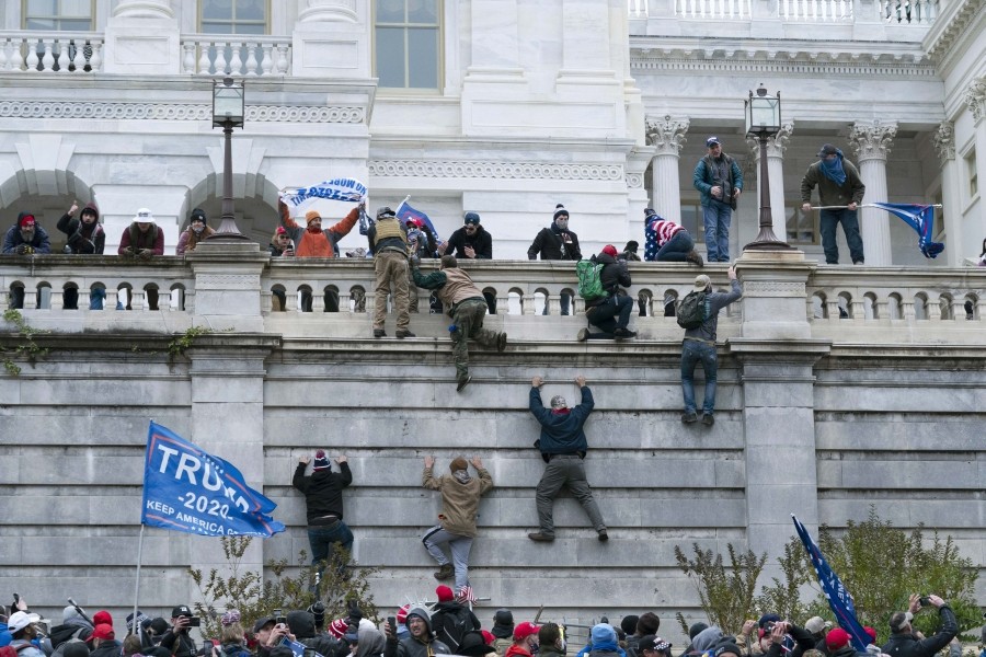 Supporters of President Donald Trump climb the west wall of the the U.S. Capitol on January 6. (AP/PTI Photo)