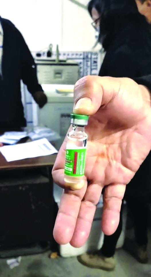 An official holds up a vial of the COVID-19 vaccine at the cold storage unit in the Directorate of Health and Family Welfare, Kohima on January 14. (Morung Photo)
