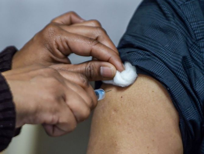 A medic administers the first shot of Covishield vaccine to a frontline worker. Photograph: Shahbaz Khan/PTI Photo