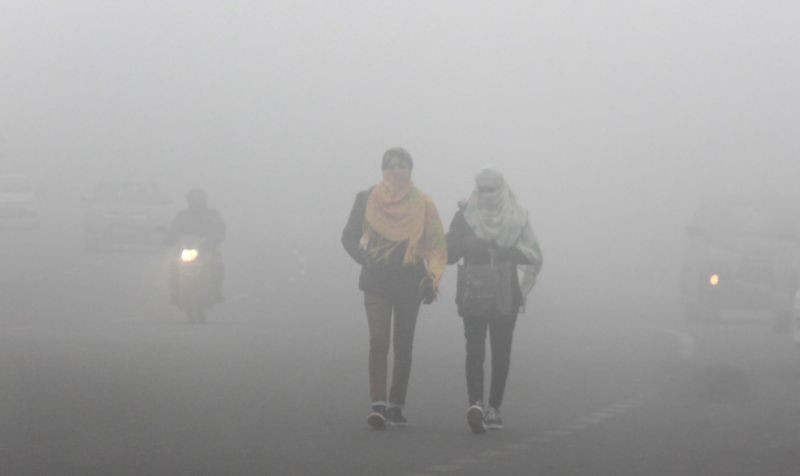 Gurugram: Commuters walk on a road amid low visibility due to fog, on a cold winter morning in Gurugram, Tuesday, Jan. 19, 2021. (PTI Photo)