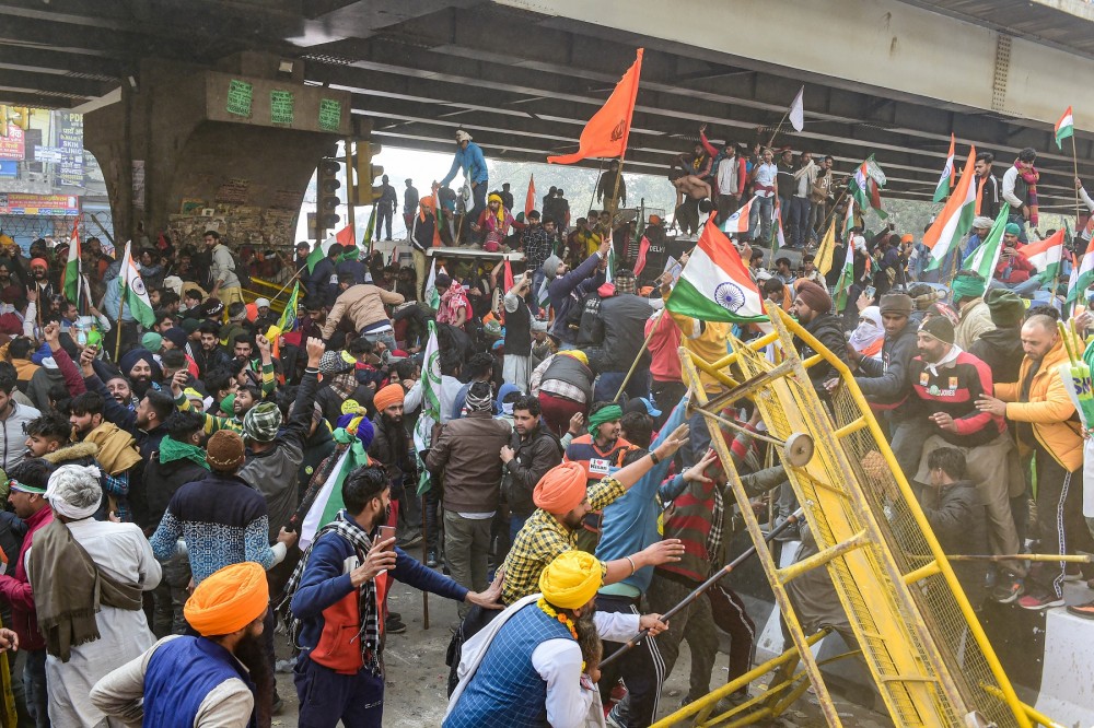 Farmers attempt to break a barricade near Nangloi as they participate in the Kisan Gantantra Parade, during their ongoing protest against Centres farm reform laws, on the occasion of 72nd Republic Day, in New Delhi on January 26. (PTI Photo/Kamal Kishore)