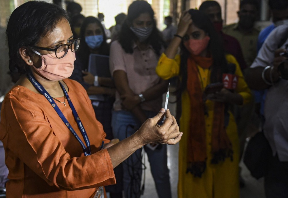 A Mumbai doctor demonstrates the use of syringes as a part of preparations for the vaccination drive. Photo: PTI