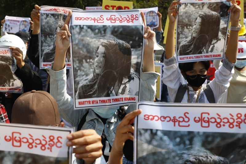 In this Feb. 14, 2021, file photo, Mandalay University graduates hold posters with images of Mya Thwet Thwet Khine, a young woman who was shot in the head by police during a protest on Feb. 9 in Naypyitaw, during an anti-coup protest in Mandalay, Myanmar. The woman shot by police during a protest against the military's takeover of power died Friday morning, Feb. 19, 2021, her brother said. (AP/PTI Photo)