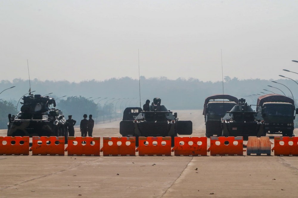 Members of the military stand guard at a checkpoint manned with an armored vehicles blocking a road leading to the parliament building Tuesday in Naypyitaw, Myanmar. AP Photo