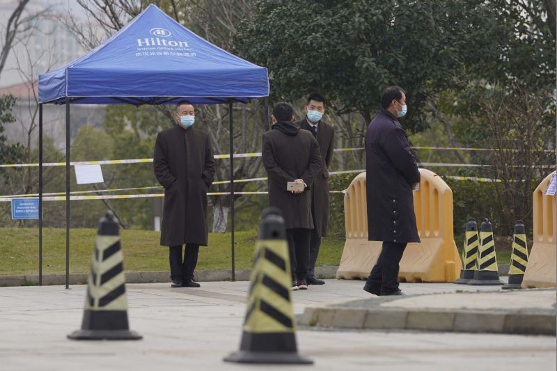 Security personnel watch a checkpoint into the cordoned off area where a World Health Organization team is staying at a hotel in central China's Hubei province on February 4, 2021. The WHO team is investigating the origins of the coronavirus pandemic in the province. (AP/PTI Photo)