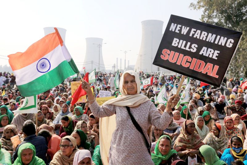 Farmers block a road during their 'chakka jam' protest as part of the ongoing agitation over new farm laws, in Bathinda on February 6. (PT Photo)