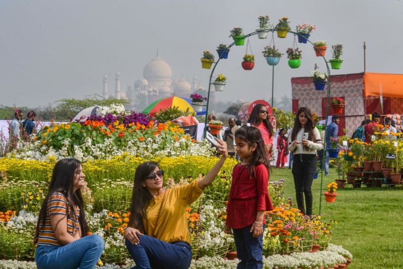 Agra: Tourists get a selfie clicked during a flower show at Red Fort, in the backdrop of the historic Taj Mahal, in Agra, Saturday, Feb. 20, 2021. (PTI Photo)
