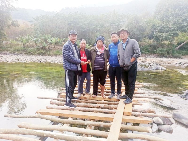 DC Longleng, M Shayung Phom handing over cash to the convenor of the bridge construction committee at the site after the DPDB meeting. (DIPR Photo)