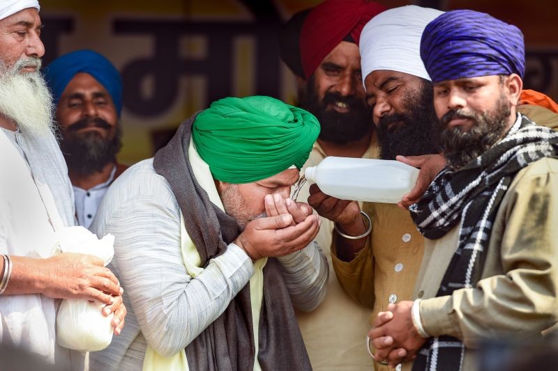 BKU spokesperson Rakesh Tikait drink holy water brought by Sikh farmers from Delhi's Gurudwara Bangla Sabib, during the ongoing protest against new farm laws, at Ghazipur border, New Delhi on February 10. ((PTI Photo)