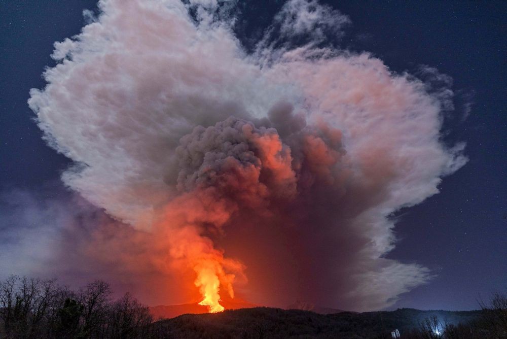 Milo: A fiery river of glowing lava flows on the north-east side of the Mt Etna volcano engulfed with ashes and smoke near Milo, Sicily, Wednesday night, Feb. 24, 2021. Europe's most active volcano has been steadily erupting since last week, belching smoke, ash, and fountains of red-hot lava. AP/PTI