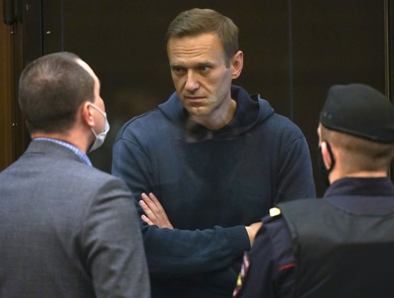 In this handout photo provided by Moscow City Court Russian opposition leader Alexei Navalny talks to one of his lawyers, left, while standing in the cage during a hearing to a motion from the Russian prison service to convert the suspended sentence of Navalny from the 2014 criminal conviction into a real prison term in the Moscow City Court in Moscow, Russia on February 2, 2021. (AP/PTI Photo)