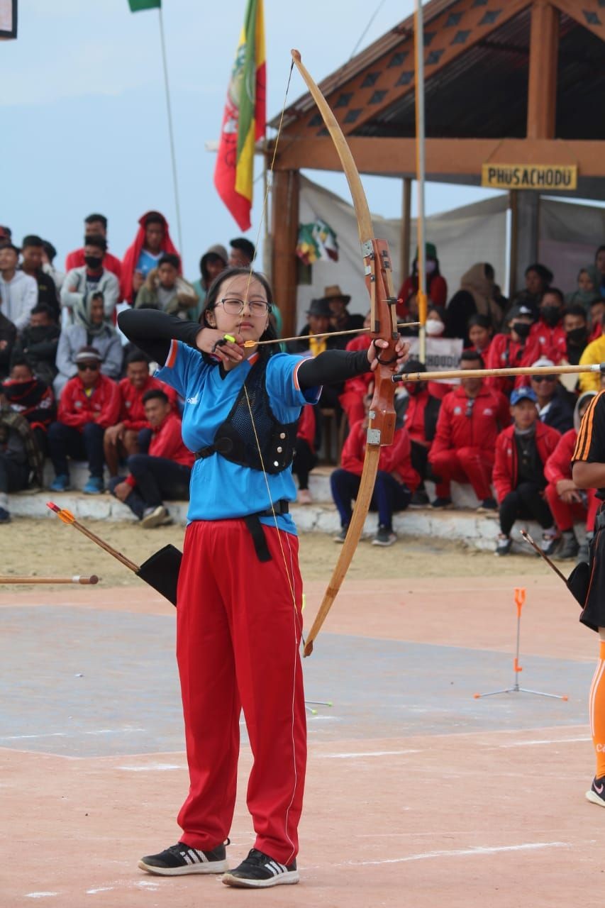 Lotsülü Sazo taking aim at the target during the archery competition.
