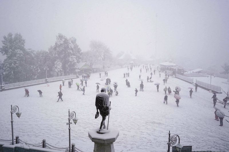 Shimla: Tourists visit the snow covered ridge amid snowfall, in Shimla, Thursday, Feb. 4, 2021. (PTI Photo)