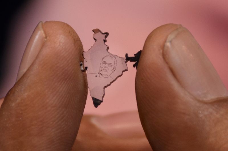 Surat: An exhibitor shows a diamond jewellery designed in the shape of India bearing a photo of PM Narendra Modi, at the gems and jewellery exhibition ' 'Sparkle 2021' in Surat, Saturday, Feb. 20, 2021. (PTI Photo) 