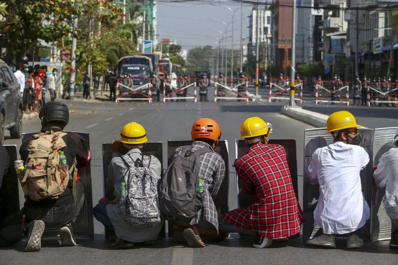 Anti-coup protesters and riot policemen face off in Mandalay, Myanmar on February 24, 2021. Protesters against the military's seizure of power in Myanmar were back on the streets of cities and towns on Wednesday, days after a general strike shuttered shops and brought huge numbers out to demonstrate. (AP/PTI Photo)
