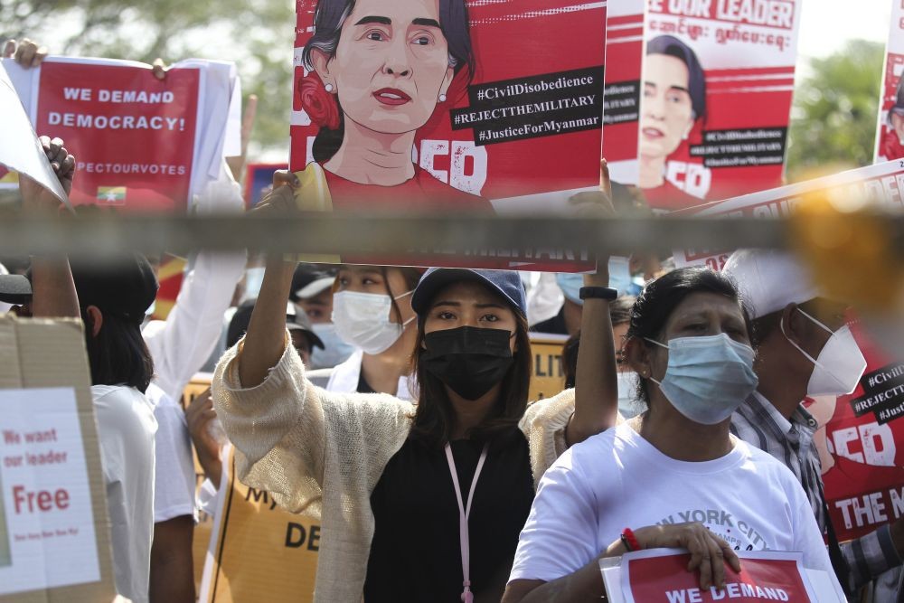 An anti-coup protester holds up a poster with an image of deposed Myanmar leader Aung San Suu Kyi during a rally outside the Central Bank of Myanmar building in Yangon, Myanmar on Monday, February 15, 2021. Myanmar's military leaders have extended their detention of Suu Kyi, whose remand was set to expire Monday and whose freedom is a key demand of the crowds of people continuing to protest this month's military coup. (Photo by AP Photo/Stringer)