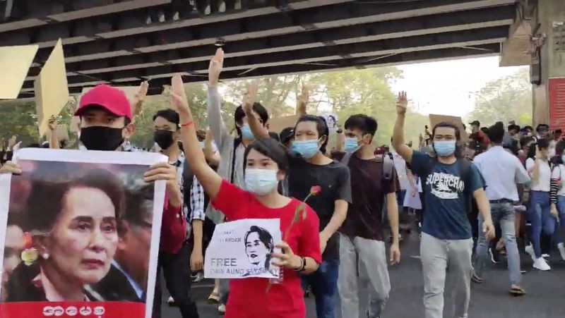 In this image made from video provided by the Democratic Voice of Burma (DVB), protesters flash the three-fingered salute and hold images of deposed Myanmar leader Aung San Suu Kyi as they march in Yangon, Myanmar on February 7.  About 2,000 protesters rallied against the military takeover in Myanmar's biggest city on Sunday and demanded the release of Aung San Suu Kyi, whose elected government was toppled by the army that also imposed an internet blackout.  (AP/PTI Photo)