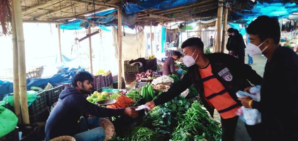 Volunteers distributing face masks to vegetable vendors at a market in Dimapur. (Morung Photo)