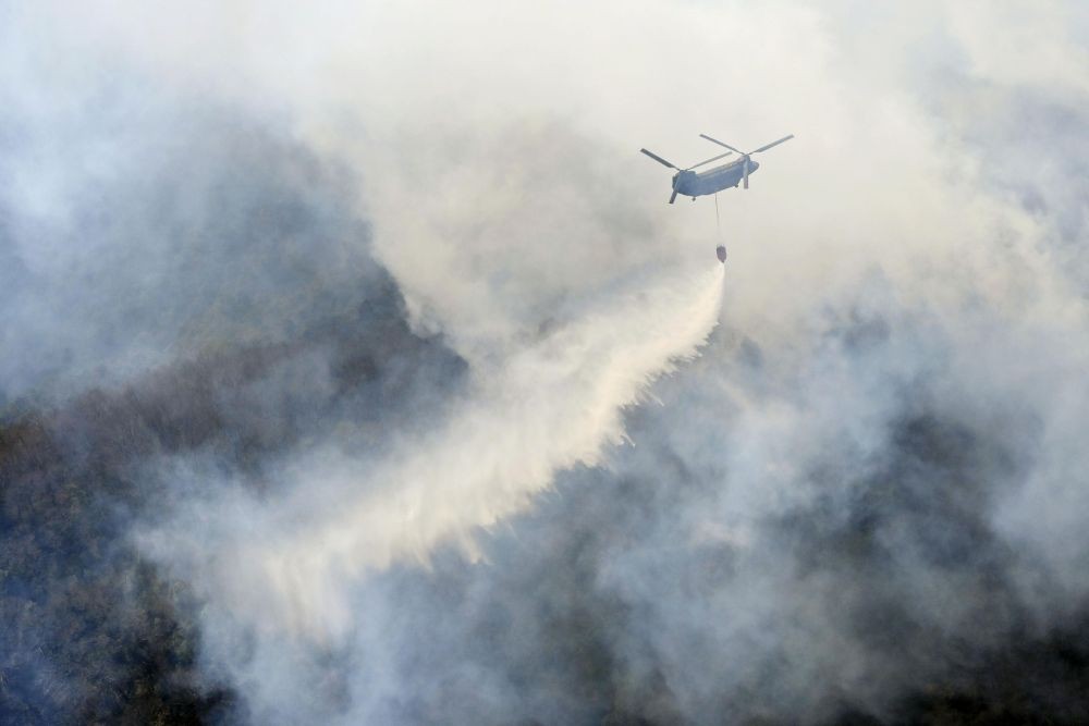 Ashikaga:A helicopter dumps water on a wildfire in Ashikaga, Tochigi prefecture, north of Tokyo Wednesday, Feb. 24, 2021. A forest fire broke out in the rural area Thursday, near another blaze burning since Sunday, Feb. 21 AP/PTI Photo