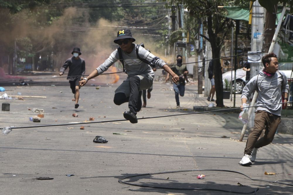 Yangon: Anti-coup protesters run to avoid military forces during a demonstration in Yangon, Myanmar on Wednesday March 31, 2021. The Southeast Asian nation has been wracked by violence since the military ousted a civilian-led government on February 1 and began to forcibly put down protests. AP/PTI