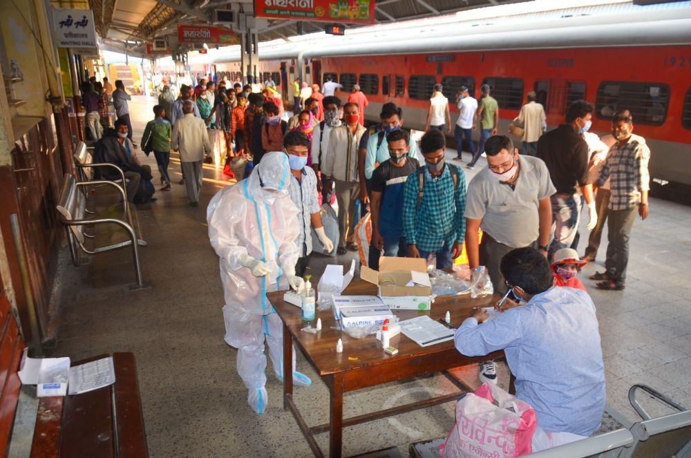 Mirzapur: Passengers wait in a queue to give samples for their COVID-19 test after arriving at a railway station, in Mirzapur, Sunday, March 21, 2021. (PTI Photo)