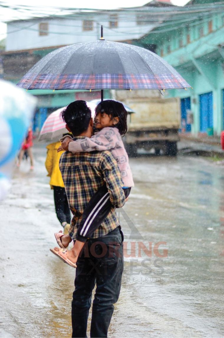  A child enjoys her moments in the rain under the umbrella in Tuensang town. (Morung Photo by Moses Hongang Chang) 
