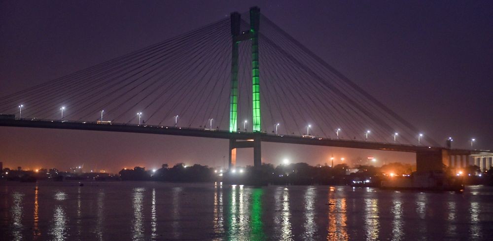 Kolkata: Pillars of Vidyasagar Setu (2nd Hooghly Bridge) illuminated in green color to mark World Glaucoma Week 2021, in Kolkata, Saturday, March 13, 2021. (PTI Photo/Swapan Mahapatra)