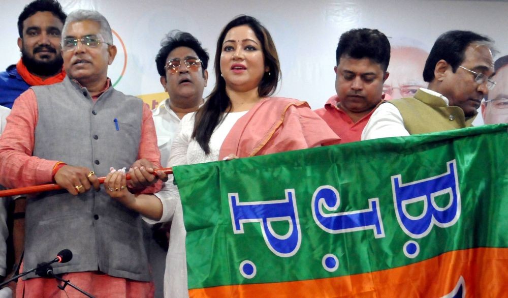 Kolkata: West Bengal BJP President MP Dilip Ghosh (L) presents party flag to Bengali actress Debhashree Bhattacharjee (C) as she joins the party ahead of State Assembly elections, in Kolkata, Saturday, March 6, 2021. (PTI Photo)