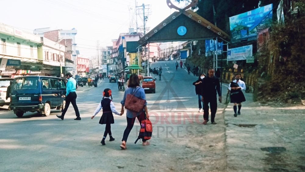 A parent takes her child to a school in Kohima on March 22. (Morung Photo)