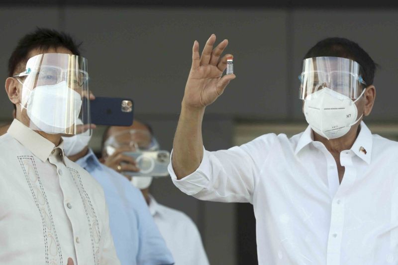 In this photo provided by the Malacanang Presidential Photographers Division, Philippine President Rodrigo Duterte, right, holds a vial containing the Sinovac vaccine from China as it arrives at the Villamor Air Base in Manila, Philippines on February 28, 2021. The Philippines received its first batch of COVID-19 vaccine Sunday, among the last in Southeast Asia to secure the critical doses despite having the second-highest number of coronavirus infections and deaths in the hard-hit region. (AP/PTI Photo)