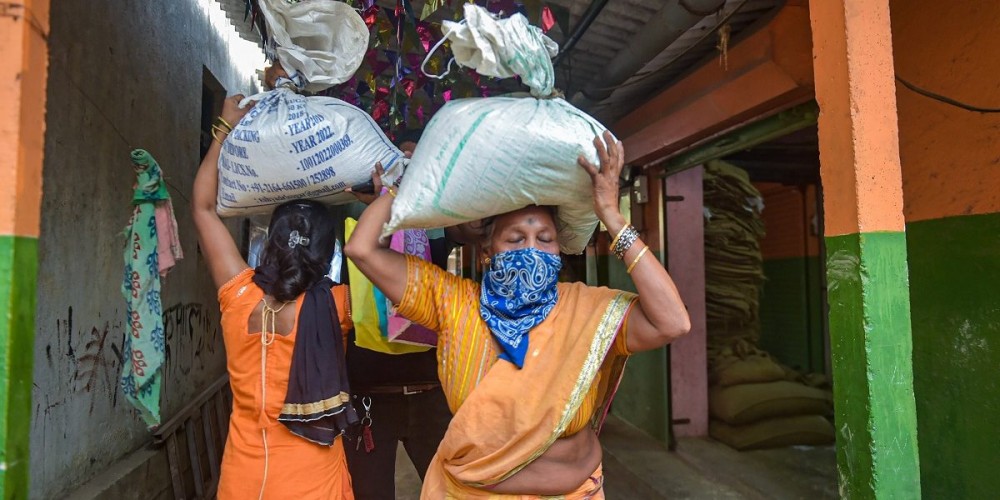 People carry essential food items after collecting them from a ration store at Pelhar village of Palghar, April 18, 2020. Photo: PTI  Photo