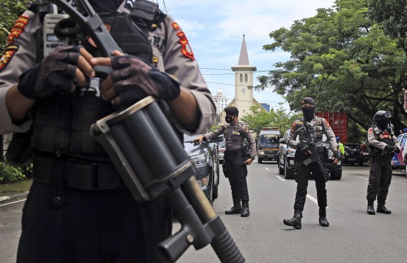 Police officers stand guard near a church where an explosion went off in Makassar, South Sulawesi, Indonesia on March 28. (AP/PTI Photo)