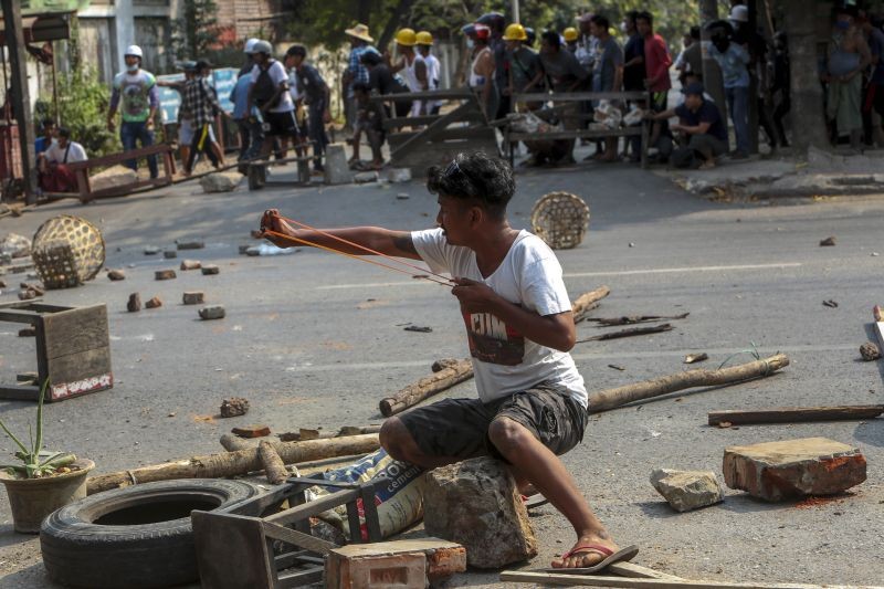 Mandalay: An anti-coup protester uses a sling-shot and against advancing riot policemen in Mandalay, Myanmar, Tuesday, March 2, 2021. Demonstrators in Myanmar took to the streets again on Tuesday to protest last month‚Äôs seizure of power by the military, as foreign ministers from Southeast Asian countries met to discuss the political crisis. Police in Yangon, Myanmar‚Äôs biggest city, used tear gas and rubber bullets against the protesters. AP/PTI